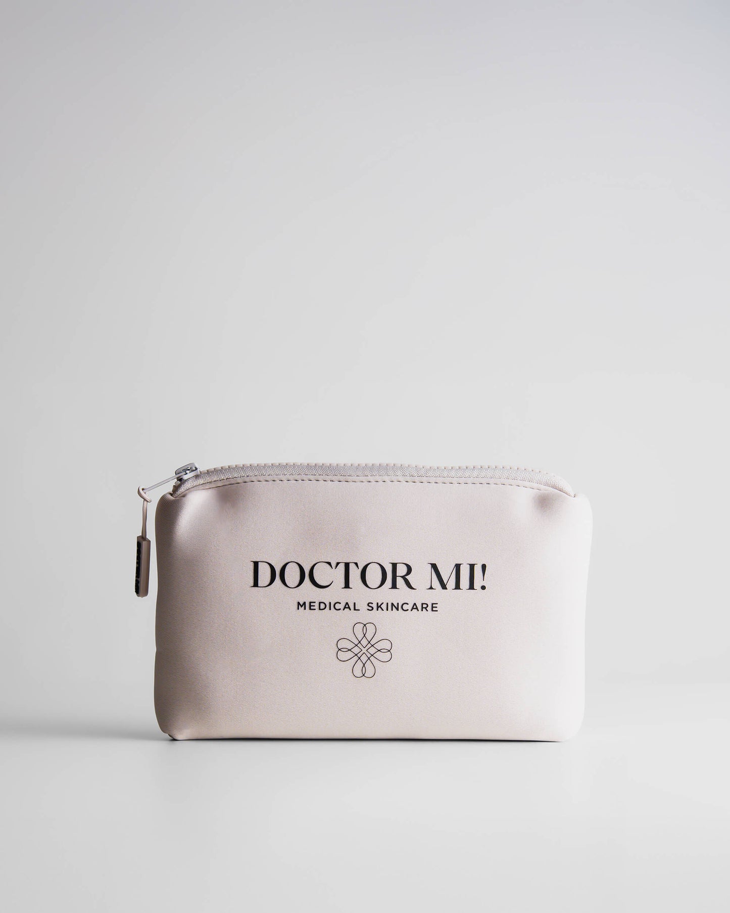 DOCTOR MI! BAG SAND Kosmetiktasche in sandfarbenem wasserabweisendem Neopren Stoff auf grauem Hintergrund