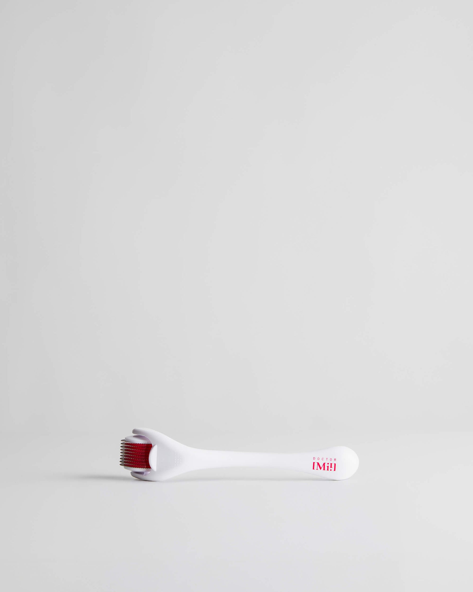 DOCTOR MI! MICRONEEDLER DERMAROLLER Edelstahlnadeln mit antibakterieller Beschichtung verleiht intensiven Boost in weißer Verpackung auf grauem Hintergrund