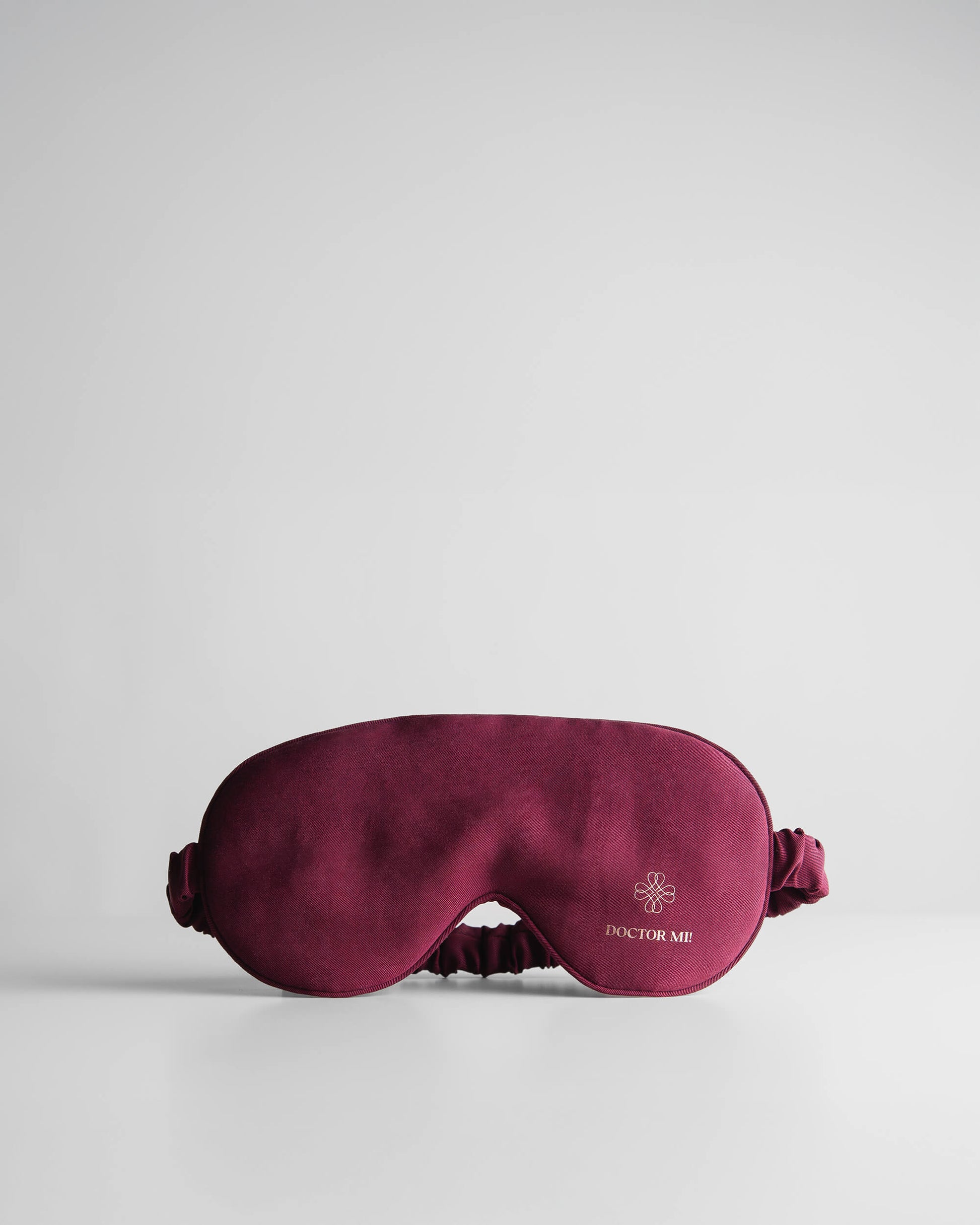DOCTOR MI! SLEEP MASK hochwertige Schlafmaske für erholsame Nächte als praktischer Reisebegleiter in rotem Material auf grauem Hintergrund