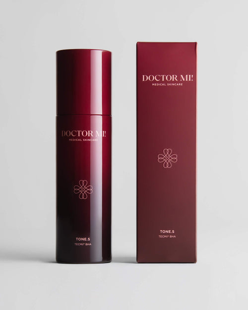 DOCTOR MI! RENEWING TONER erfrischender Toner mit AHA und BHA für ein strahlendes Hautbild im roten Pumpspender neben roter Verpackung auf grauem Hintergrund