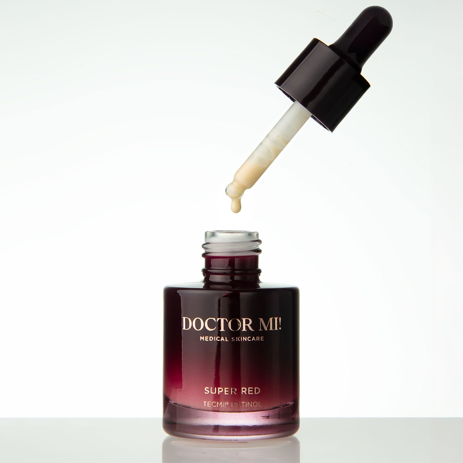 DOCTOR MI! SUPER RED SERUM overnight refining treatment Serum mit Retinol TECMi!® Technologie mit offenem rotem Glasflakon und Pipette mit dickflüssiger hochwirksamer Textur auf weißem Hintergrund