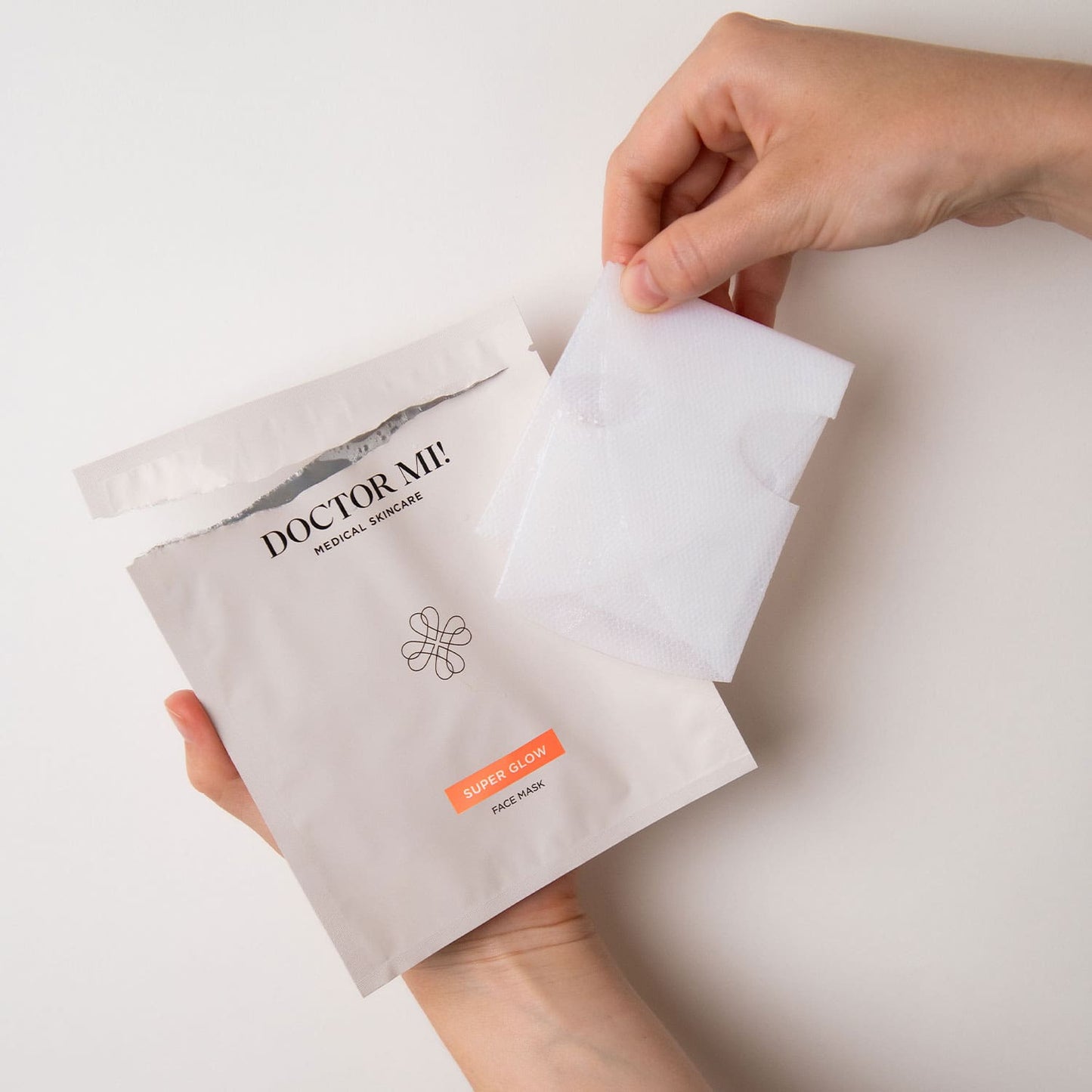 DOCTOR MI! SUPER GLOW FACE MASK sanfte exfolierende Gesichtsmaske für ein verfeinertes Hautbild in offener weißer Verpackung mit weißer natürlichen Biocellulose-Fasern
