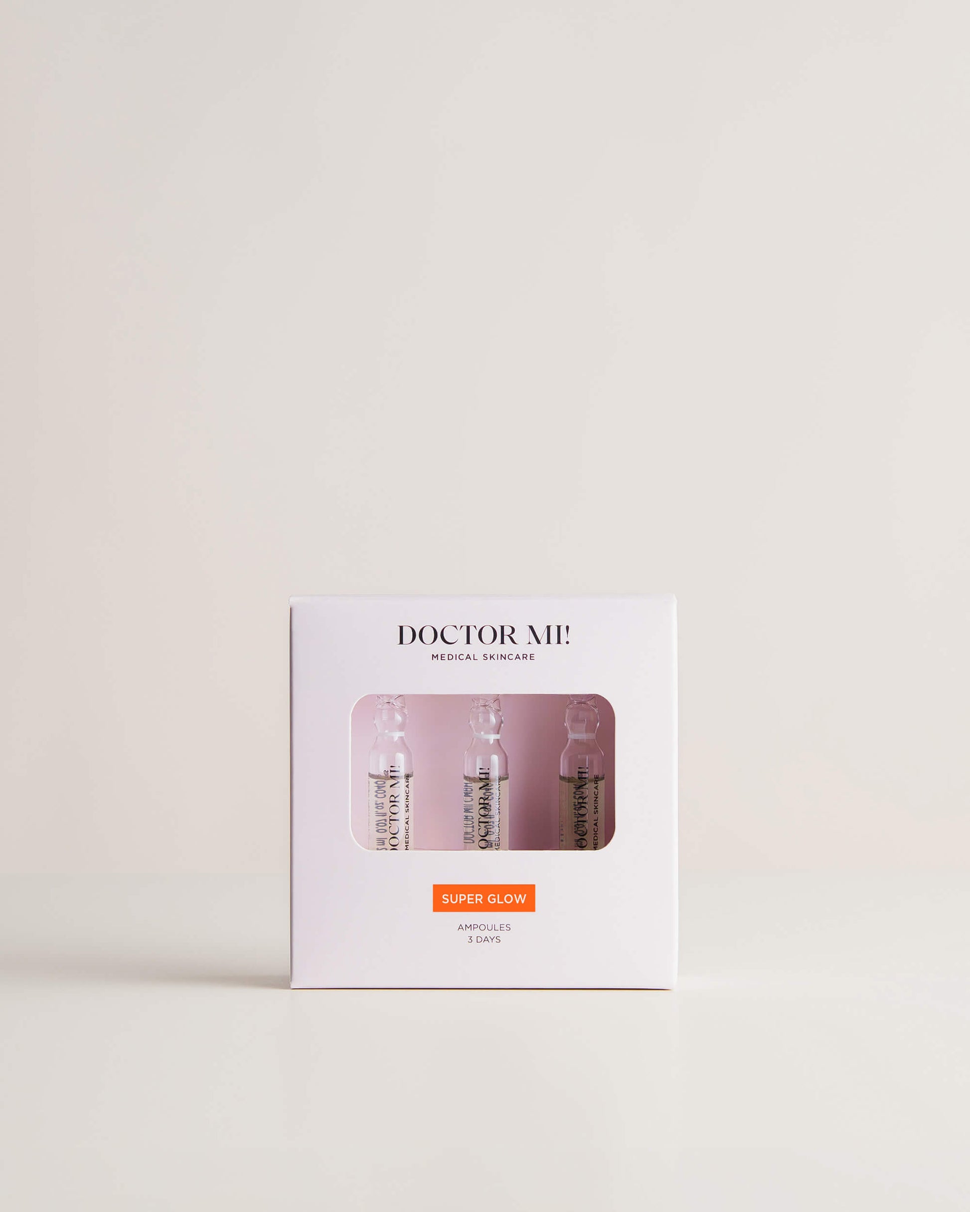 DOCTOR MI! SUPER GLOW AMPOULES kraftvolle Pflegekur für intensiven Glow Boost und einen frischen, strahlenden Teint in weißer Verpackung auf grauem Hintergrund 