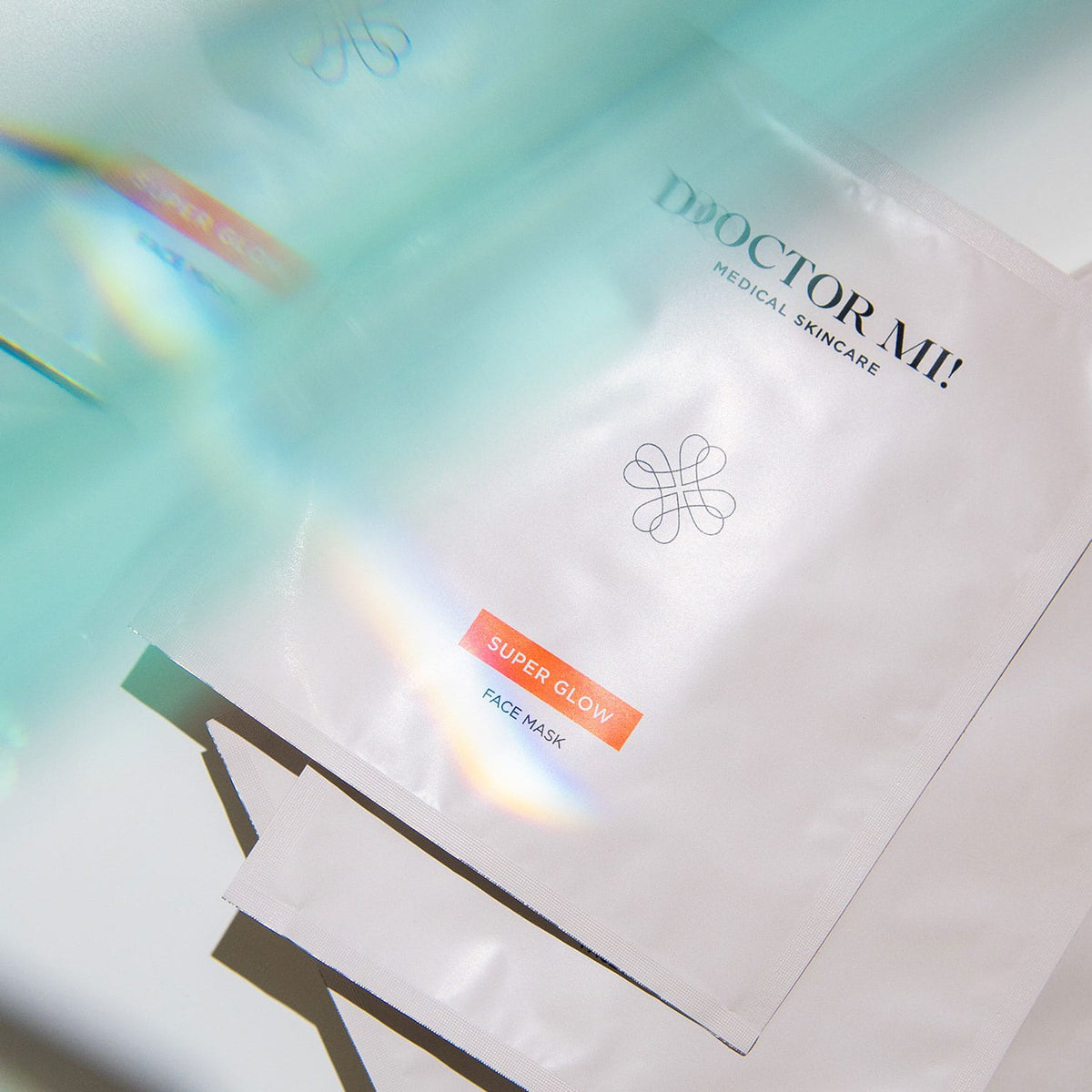 DOCTOR MI! SUPER GLOW FACE MASK sanfte exfolierende Gesichtsmaske für ein verfeinertes Hautbild aus natürlichen Biocellulose-Fasern in weißer Verpackung auf weißem Hintergrund 