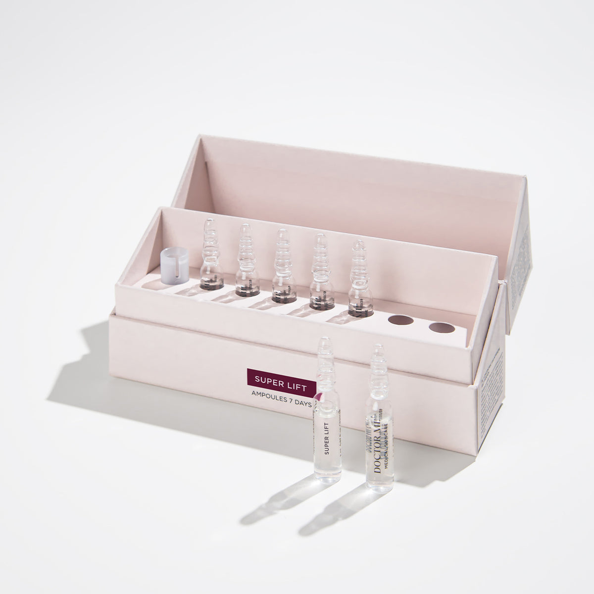 DOCTOR MI! SUPER LIFT AMPOULES tiefenwirksame Anti-Aging Lifting Ampullen, glättet feine Linien und Fältchen in weißer Verpackung mit Glasampullen auf grauem Hintergrund 